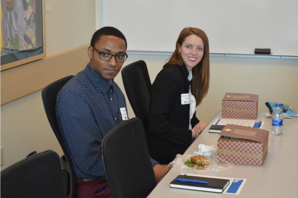 Two alumni sitting at a table at the 30 Minute Mentors Event